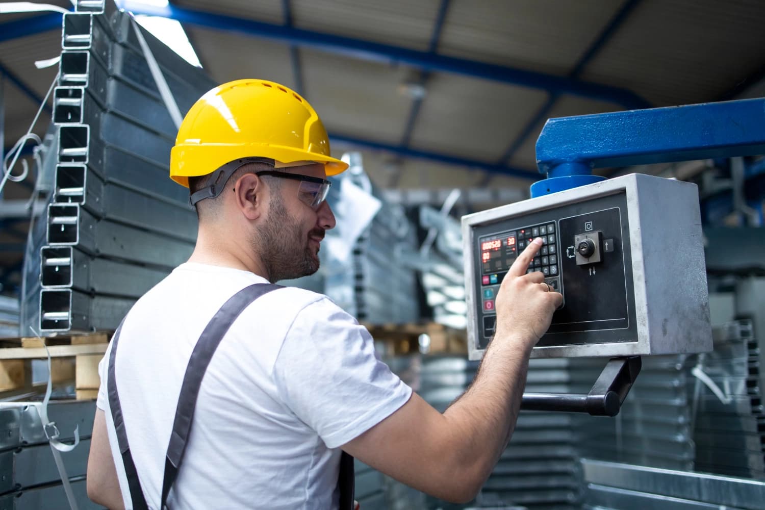 Operador MTE ajustando el control numérico de una máquina CNC en planta